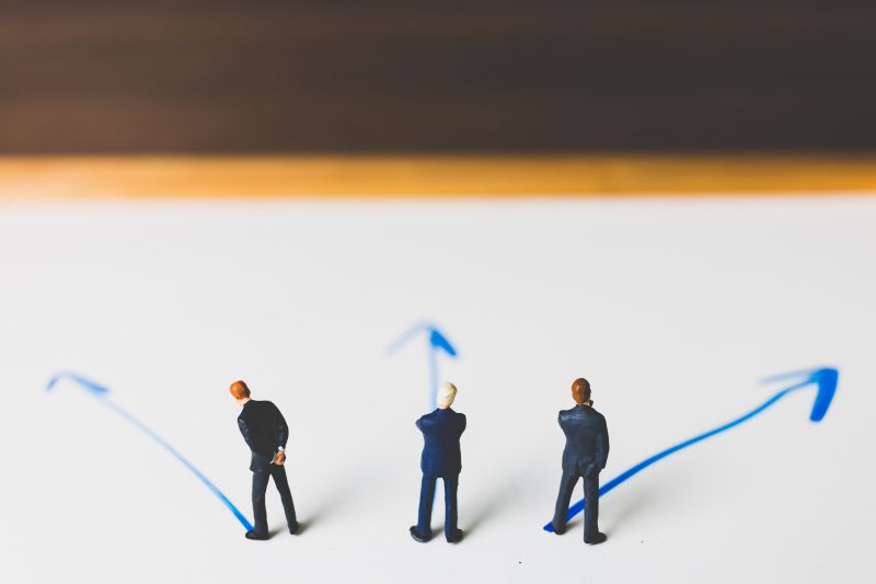 Miniature Businessman standing on arrow pathway , Business decis Users being lost